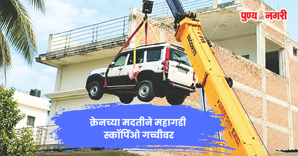 क्रेनच्या मदतीने दुसऱ्या मजल्यावरील गच्चीवर नेली जात असलेली स्कॉर्पिओ कार